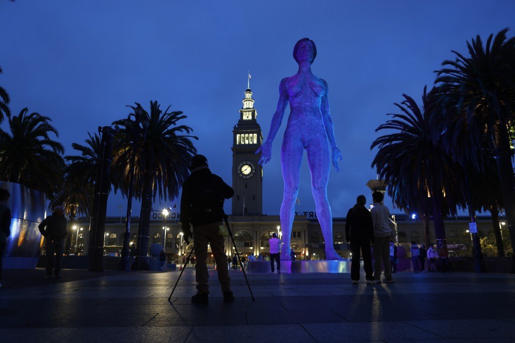 The 45-foot-tall metal sculpture of a nude woman, R-Evolution, by artist Marco Cochrane, stands in the Embarcadero Plaza.