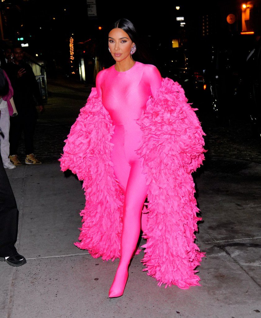 Kim Kardashian arrives at the Saturday Night Live afterparty wearing a bright pink full-body suit with a matching feathery boa.